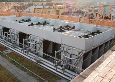 A picture of a major HVAC installation project taken from the second floor of construction. Several grouped unites are put in place with surrounding wood frames built up around it. 