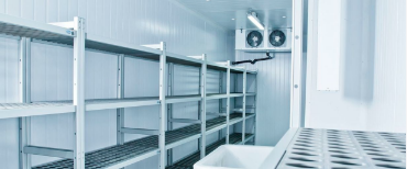 Image of the inside of a refrigerated room in a commercial building with blower fans mounted on the back wall.