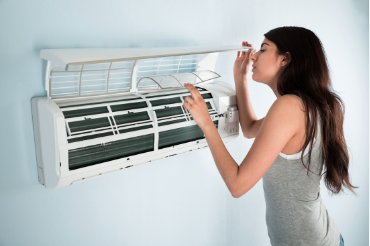 Image of a woman troubleshooting issues on a failed home ductless air conditioning unit.